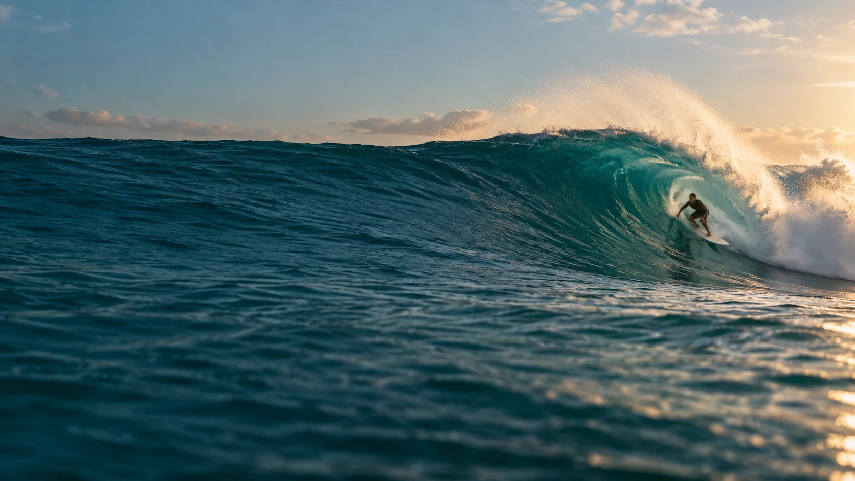 A surfer riding a sunlit Atlantic wave